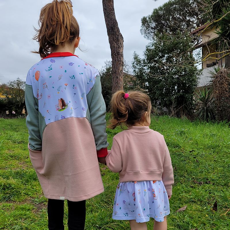 dvije djevojčice okrenute s leđa u personaliziranoj odjeći sa cvjetnim motivima